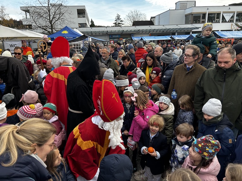 Menschenmenge auf dem Dorfplatz beim Weihnachtsmarkt